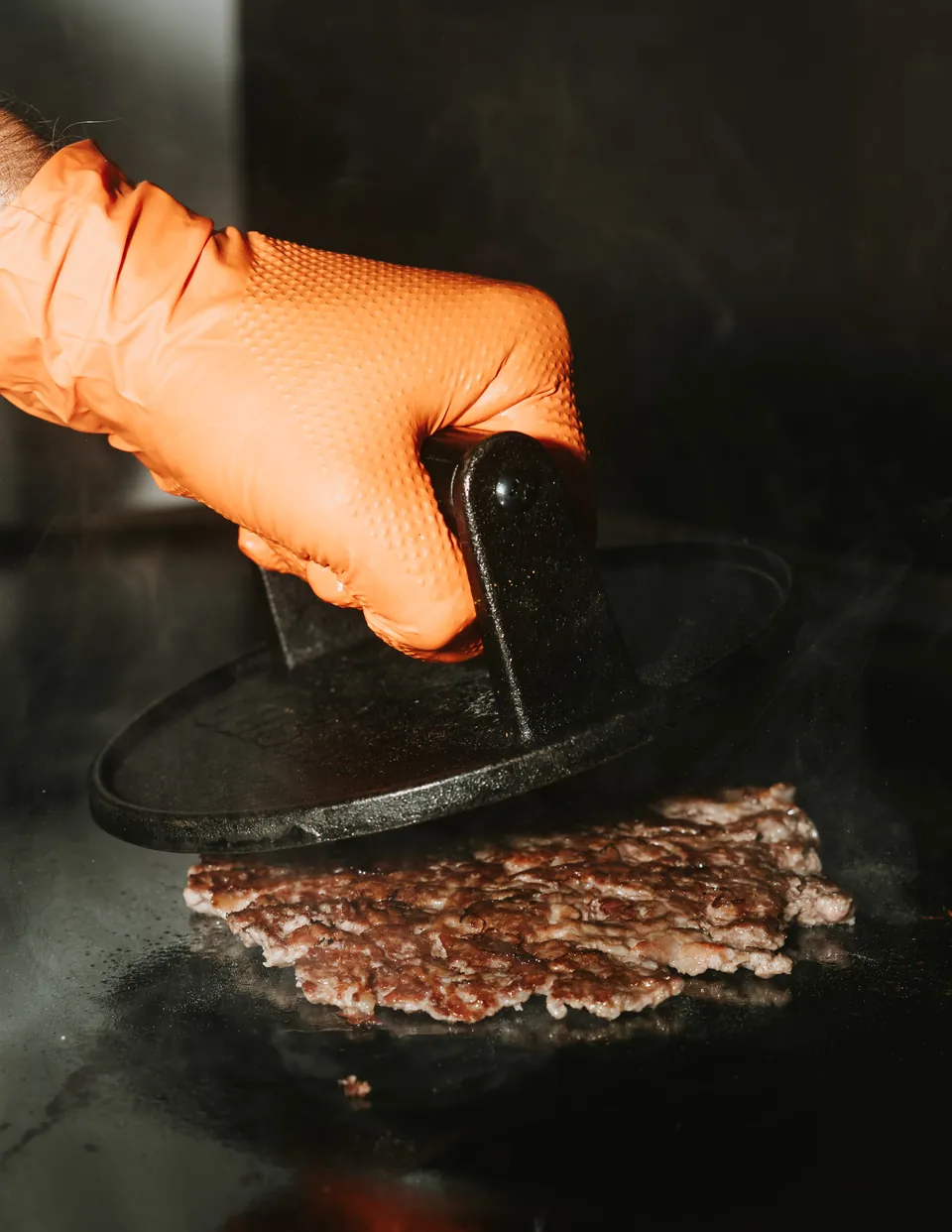 La prensa aplasta la carne en la plancha