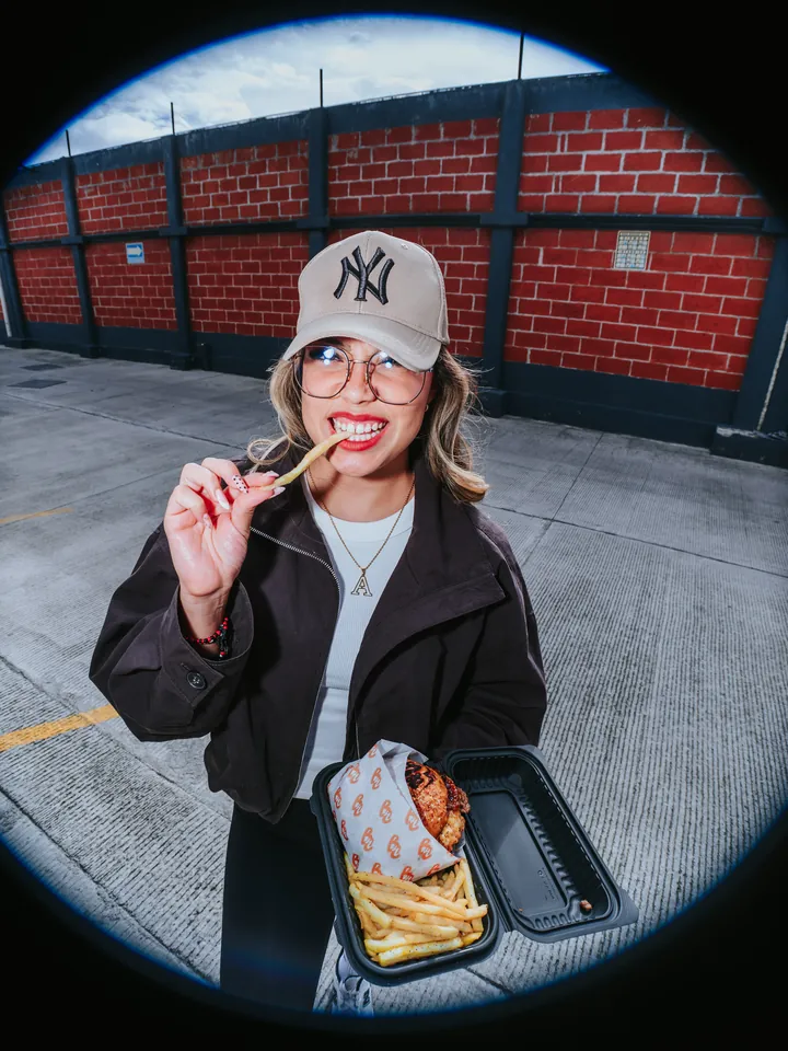 Papas y burger en el estacionamiento, con gorra de los Yankees