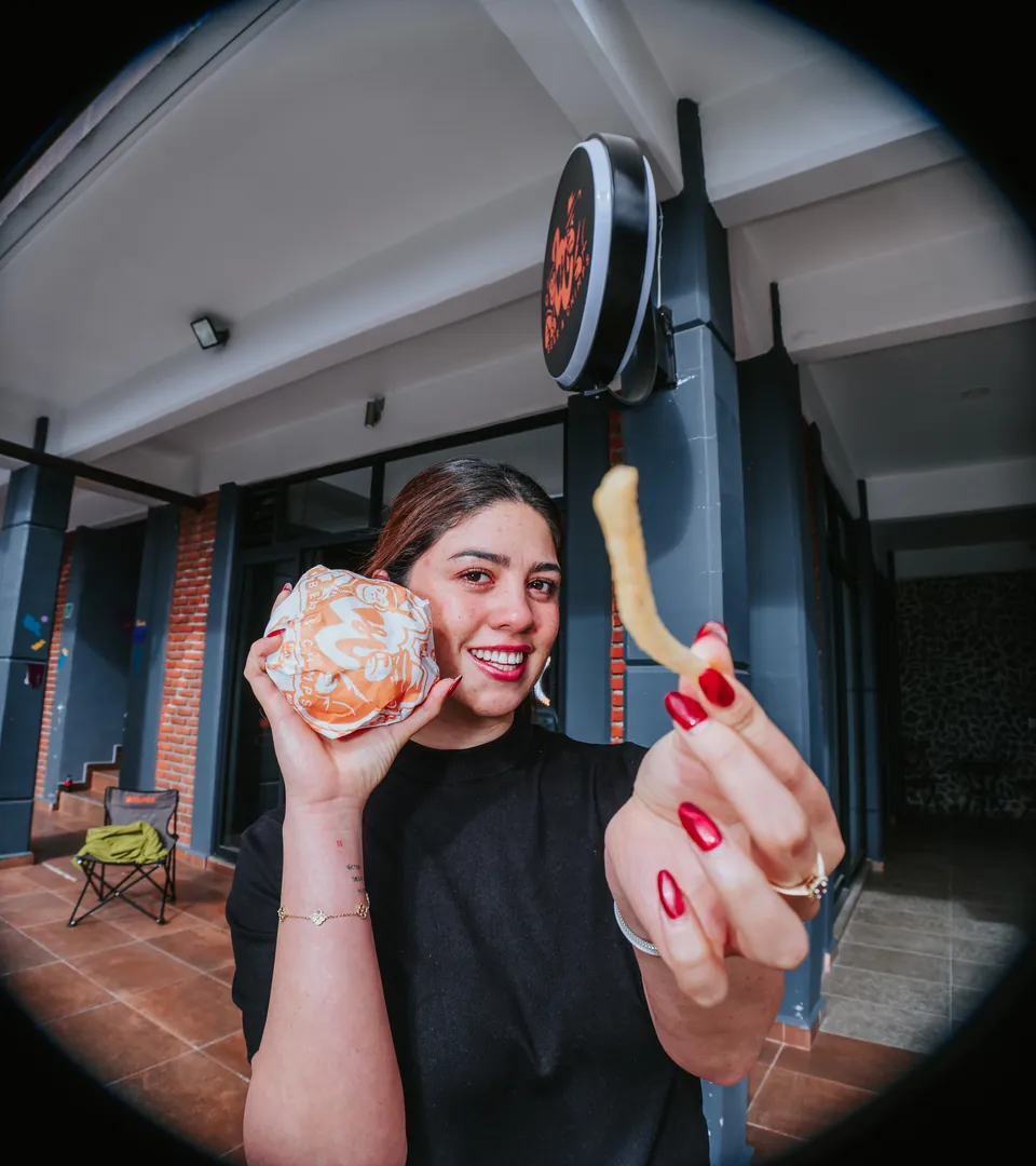 Chica con su burger bajo el letrero de Bear&Chimps