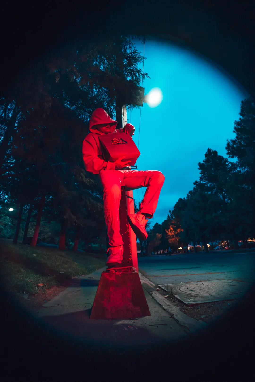 Chico con sudadera roja y su bolsa de Bear&Chimps, de noche
