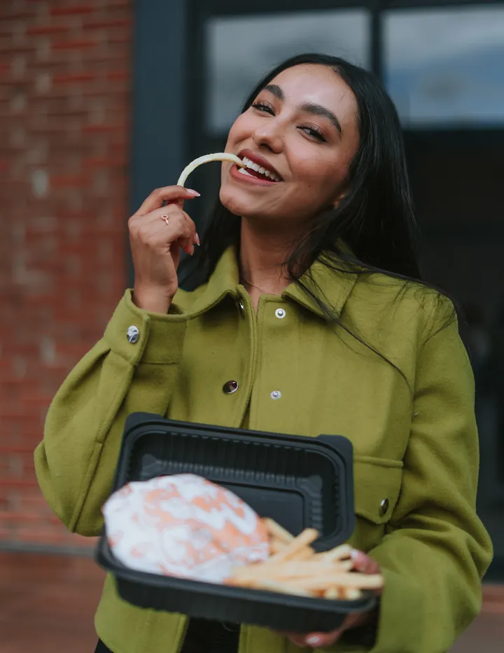 Chica con chamarra verde y papas