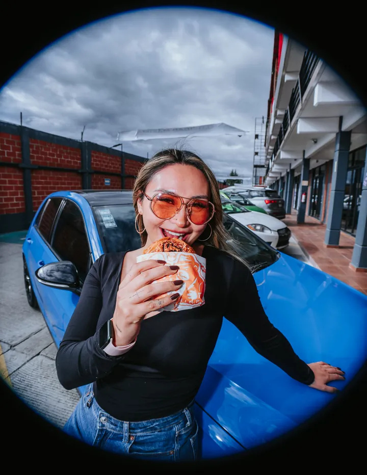 Con su burger recargada en el coche azul