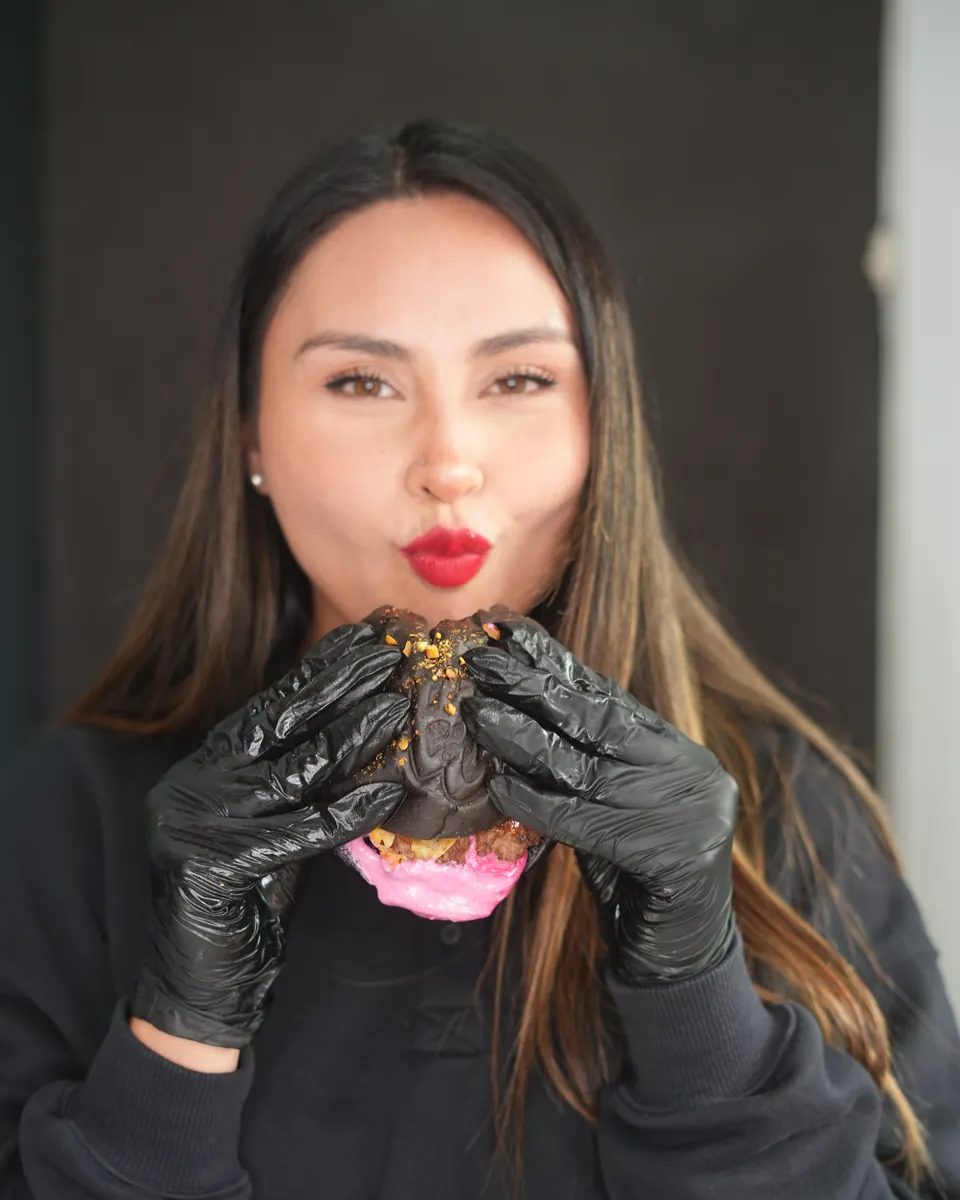 Beso a la burger con guantes negros